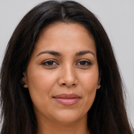 Joyful latino young-adult female with long  brown hair and brown eyes