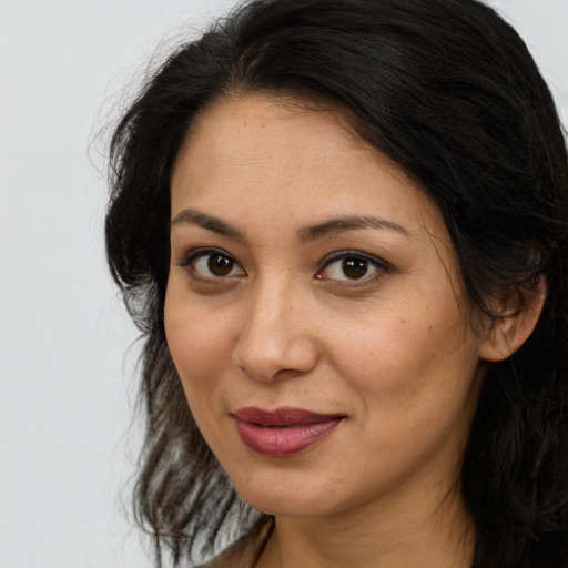 Joyful latino young-adult female with long  brown hair and brown eyes