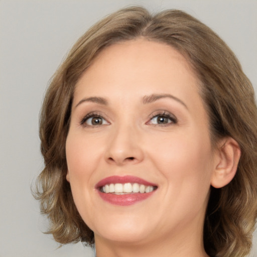 Joyful white young-adult female with medium  brown hair and green eyes