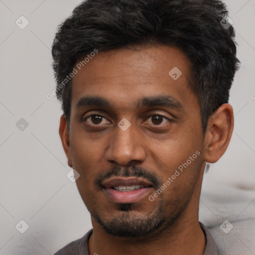 Joyful black young-adult male with short  black hair and brown eyes
