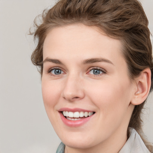 Joyful white young-adult female with medium  brown hair and blue eyes