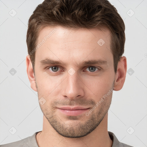 Joyful white young-adult male with short  brown hair and grey eyes