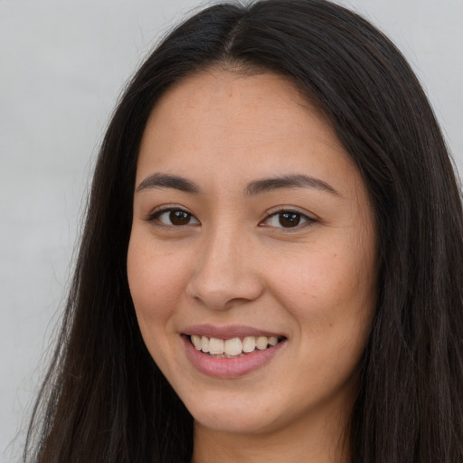 Joyful white young-adult female with long  brown hair and brown eyes