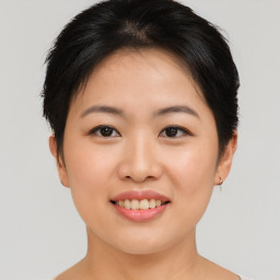 Joyful asian young-adult female with short  brown hair and brown eyes