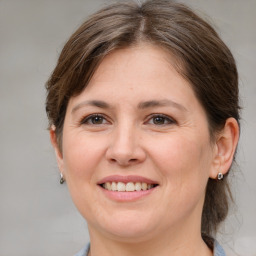 Joyful white adult female with medium  brown hair and grey eyes