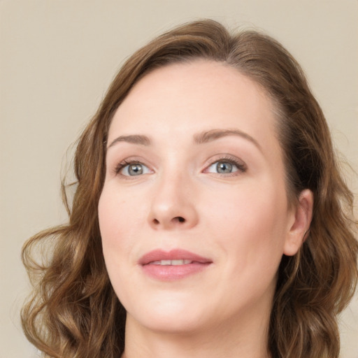 Joyful white young-adult female with long  brown hair and blue eyes