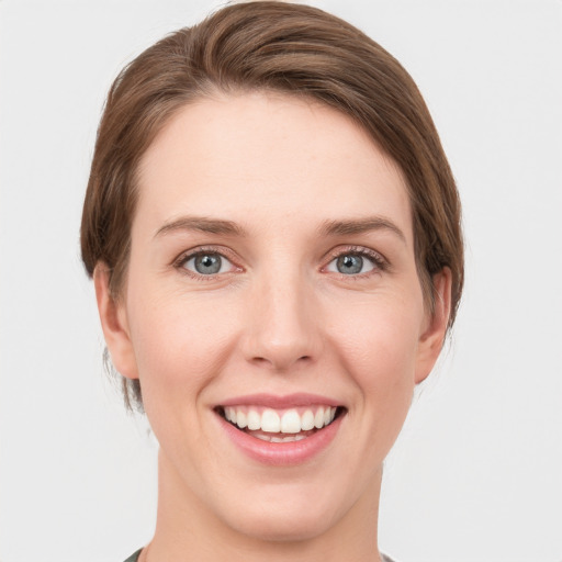 Joyful white young-adult female with short  brown hair and grey eyes