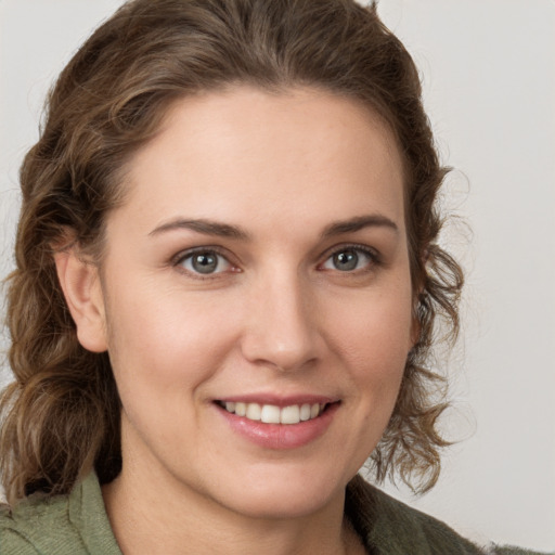 Joyful white young-adult female with medium  brown hair and green eyes