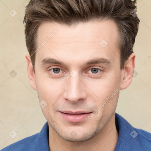 Joyful white young-adult male with short  brown hair and grey eyes