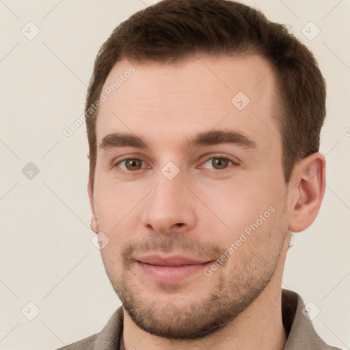 Joyful white young-adult male with short  brown hair and grey eyes