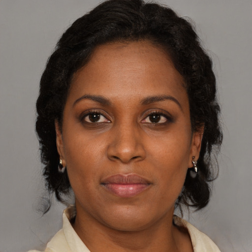 Joyful black adult female with medium  brown hair and brown eyes