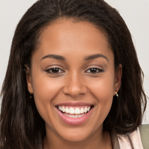 Joyful latino young-adult female with long  brown hair and brown eyes