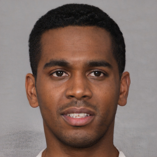 Joyful black young-adult male with short  brown hair and brown eyes