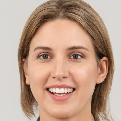 Joyful white young-adult female with medium  brown hair and grey eyes