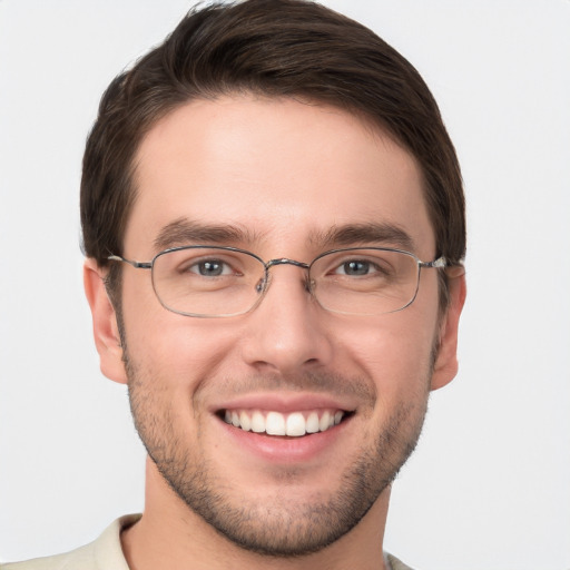 Joyful white young-adult male with short  brown hair and grey eyes