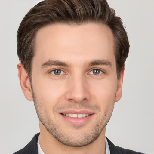 Joyful white young-adult male with short  brown hair and grey eyes