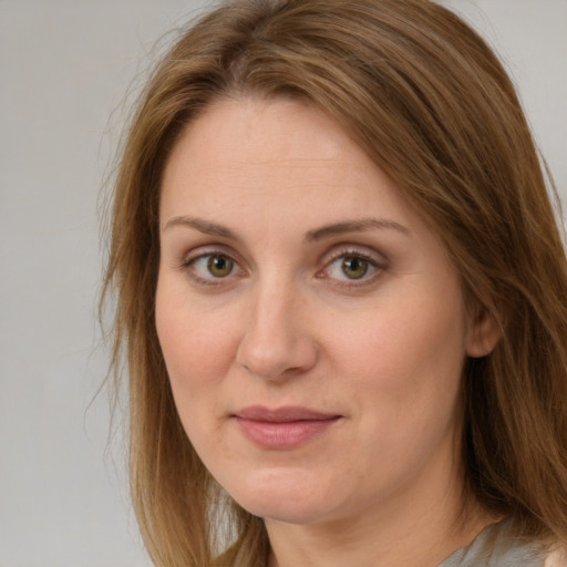 Joyful white adult female with long  brown hair and green eyes