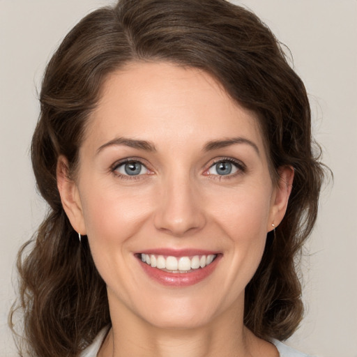 Joyful white young-adult female with medium  brown hair and green eyes