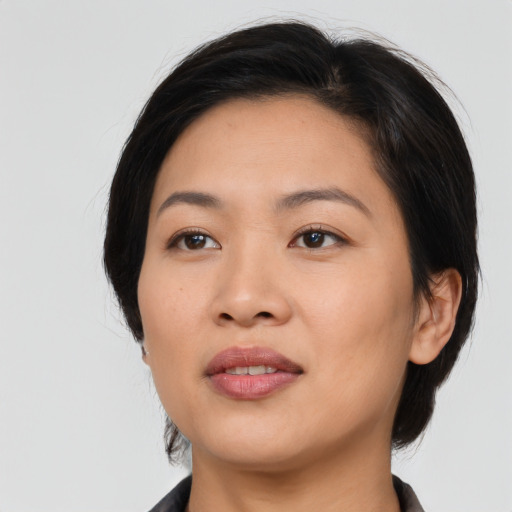 Joyful asian young-adult female with medium  black hair and brown eyes