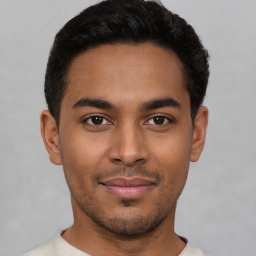 Joyful latino young-adult male with short  black hair and brown eyes