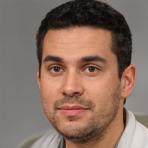 Joyful white adult male with short  black hair and brown eyes