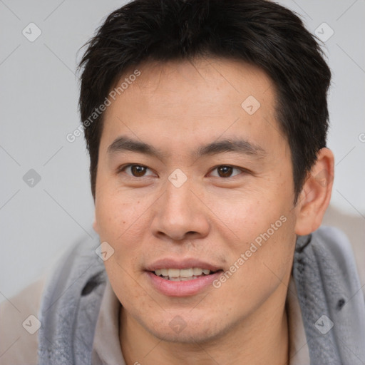 Joyful asian adult male with short  brown hair and brown eyes