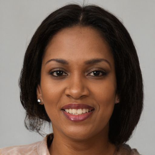 Joyful black young-adult female with medium  brown hair and brown eyes