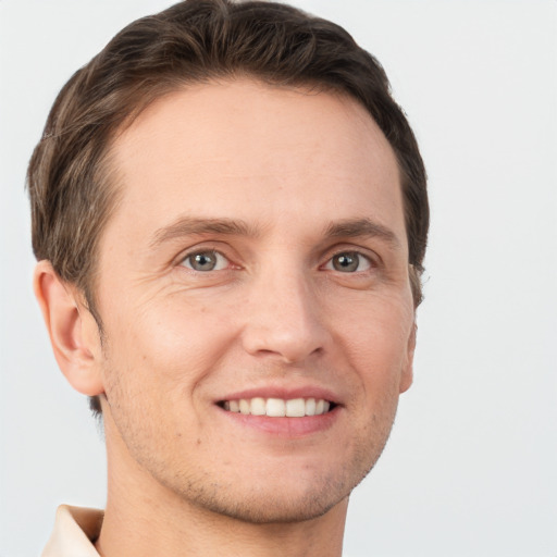 Joyful white young-adult male with short  brown hair and grey eyes