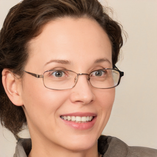 Joyful white adult female with medium  brown hair and grey eyes