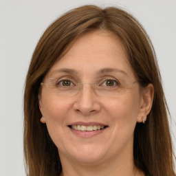 Joyful white adult female with long  brown hair and grey eyes