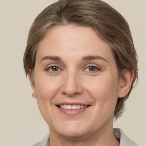 Joyful white adult female with medium  brown hair and grey eyes