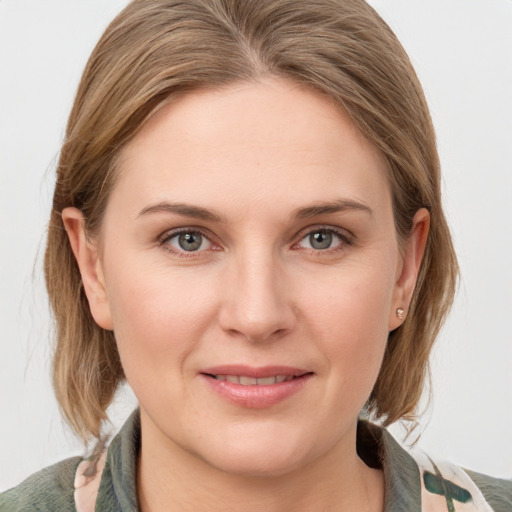 Joyful white young-adult female with medium  brown hair and grey eyes