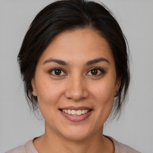 Joyful latino young-adult female with medium  brown hair and brown eyes