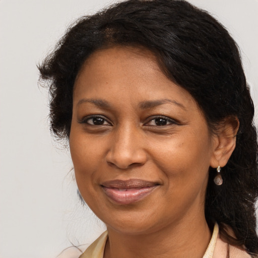 Joyful black adult female with long  brown hair and brown eyes