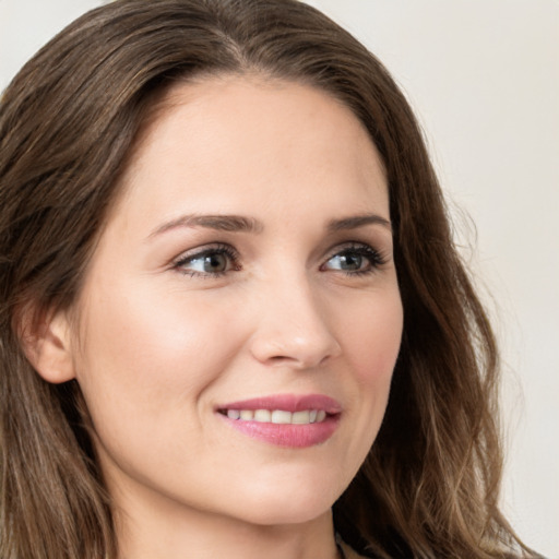 Joyful white young-adult female with long  brown hair and green eyes