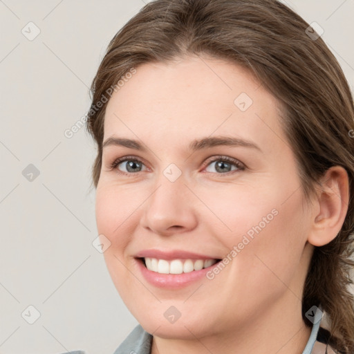 Joyful white young-adult female with medium  brown hair and grey eyes