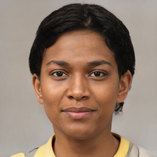 Joyful black young-adult female with short  black hair and brown eyes
