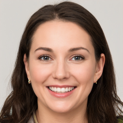 Joyful white young-adult female with long  brown hair and brown eyes