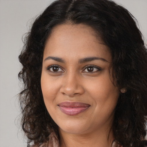 Joyful black young-adult female with long  brown hair and brown eyes