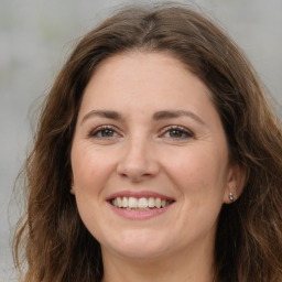 Joyful white adult female with long  brown hair and brown eyes