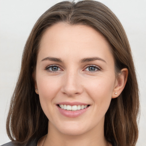 Joyful white young-adult female with long  brown hair and grey eyes