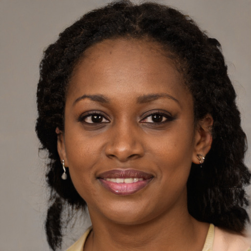 Joyful black young-adult female with medium  brown hair and brown eyes