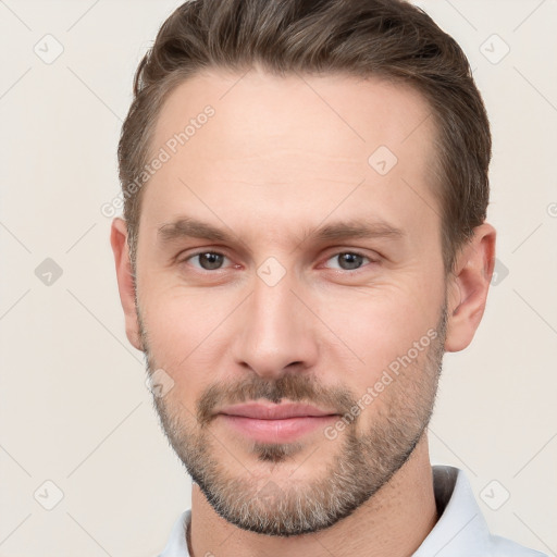 Joyful white young-adult male with short  brown hair and grey eyes