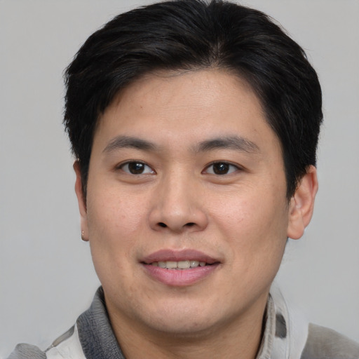 Joyful asian young-adult male with short  brown hair and brown eyes