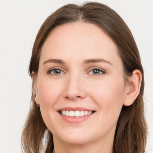 Joyful white young-adult female with long  brown hair and grey eyes