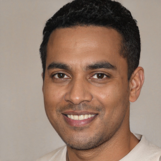 Joyful black young-adult male with short  black hair and brown eyes