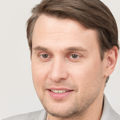 Joyful white young-adult male with short  brown hair and grey eyes