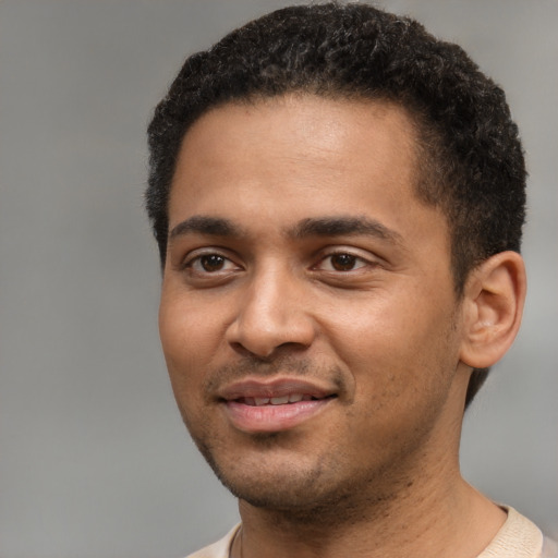 Joyful black young-adult male with short  brown hair and brown eyes