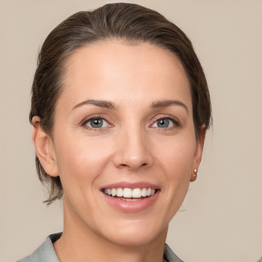 Joyful white young-adult female with medium  brown hair and grey eyes