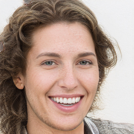 Joyful white young-adult female with long  brown hair and green eyes